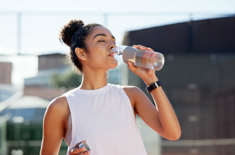 Eine Sportlerin trinkt Wasser