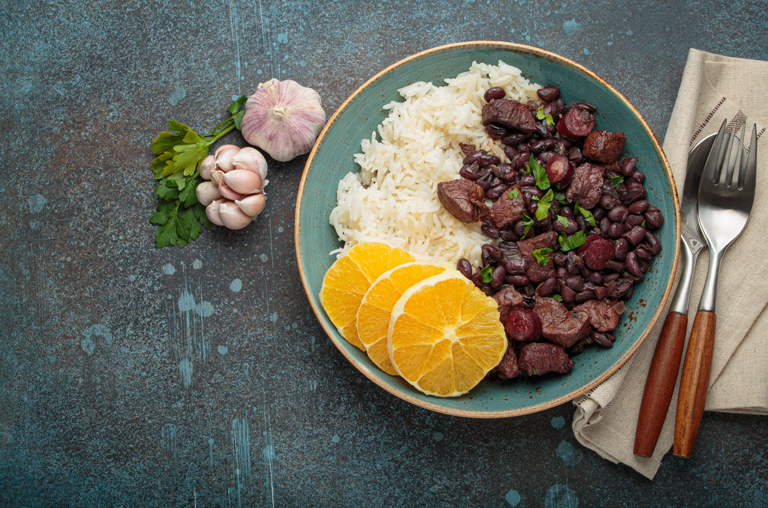 Gericht Brasilianische Feijoada mit Reis und Orange