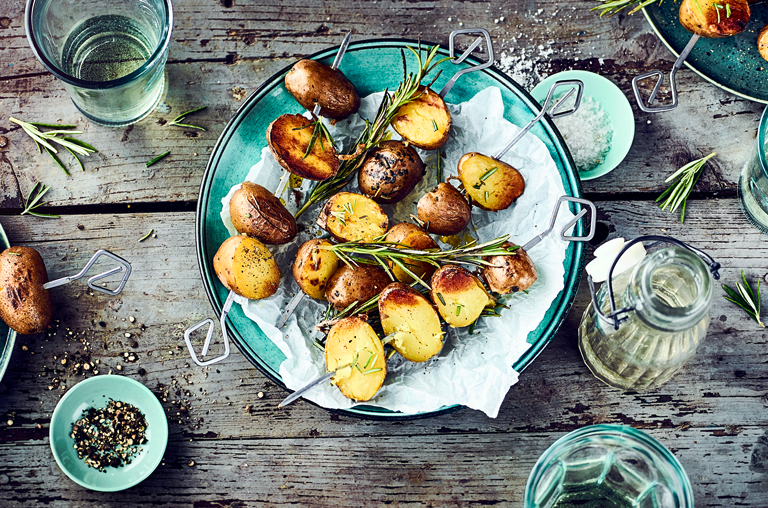 Zum Internationaler Tag der Kartoffel Hände, Rezeptbild EDEKA für Rosmarinkartoffel auf Spieß